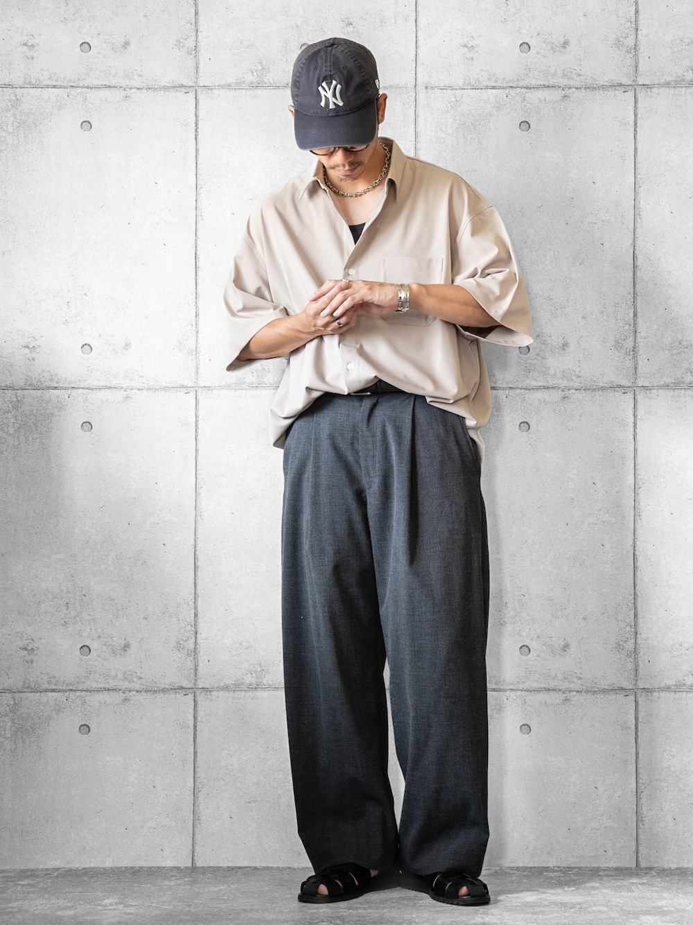 ベージュ系のシャツ/ブラウス、グレー系のスラックス、ブラック系のサンダルを着用したメンズの夏コーディネートの1枚目の写真