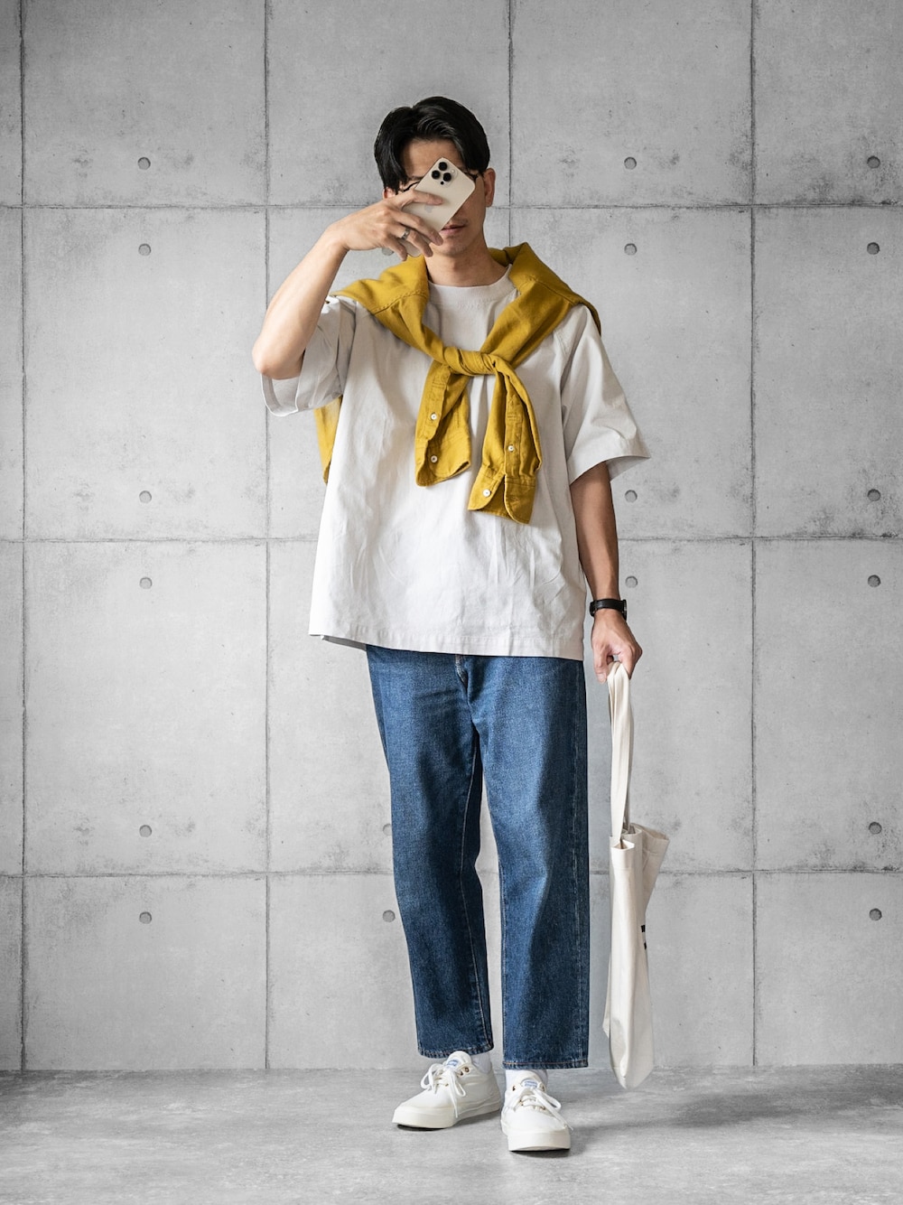 グレー系のTシャツ/カットソー、ブルー系のデニムパンツ、ホワイト系のスニーカーを着用したメンズの春コーディネートの1枚目の写真