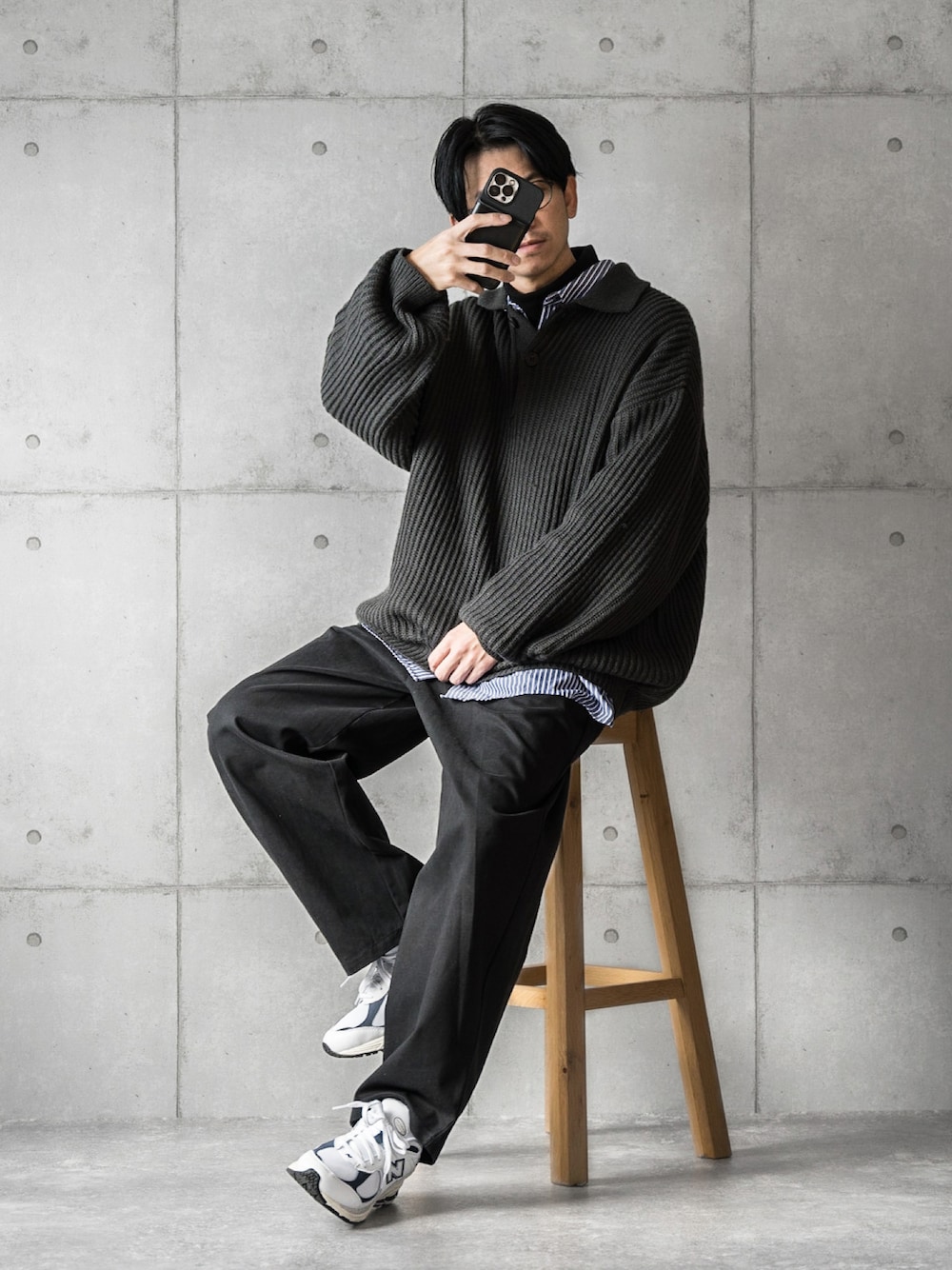 ブラック系のニット/セーター、ブルー系のシャツ/ブラウス、ホワイト系のスニーカーを着用したメンズの秋コーディネートの1枚目の写真