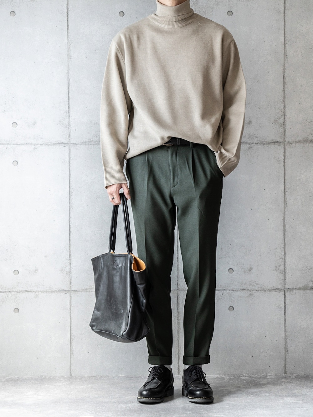 ベージュ系のニット/セーター、グリーン系のスラックス、ブラック系のトートバッグを着用したメンズの秋コーディネートの1枚目の写真