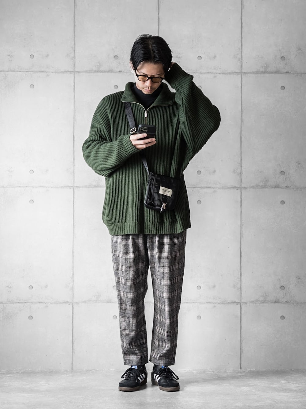 グリーン系のニット/セーター、ブラック系のその他パンツ、ブラック系のスニーカーを着用したメンズの冬コーディネートの1枚目の写真