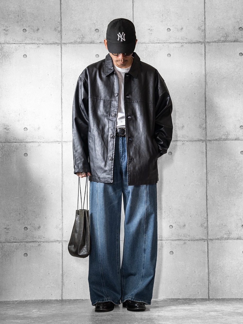 ブラック系のブルゾン、ブルー系のデニムパンツ、ブラック系のショルダーバッグを着用したメンズの春コーディネートの1枚目の写真