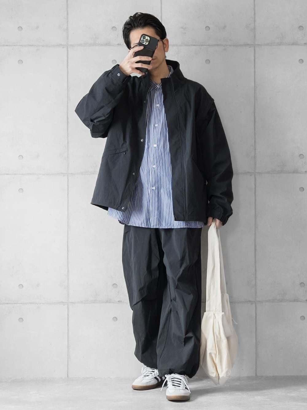ブラック系のブルゾン、ブラック系のその他パンツ、ブルー系のシャツ/ブラウスを着用したメンズの春コーディネートの1枚目の写真
