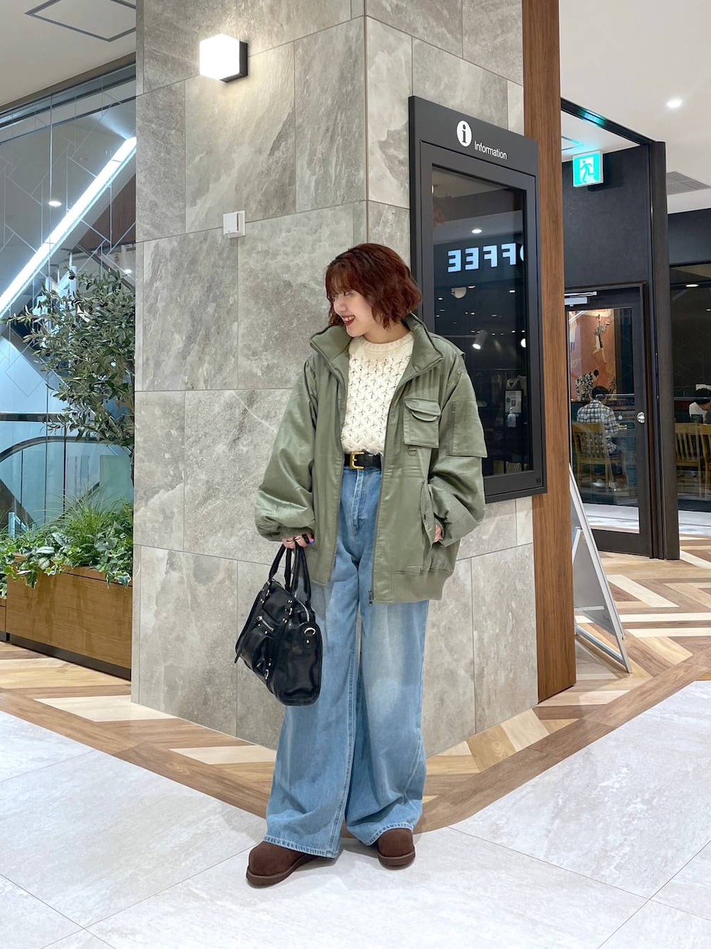 ブルー系のデニムパンツ、ブラック系のボストンバッグ、ブラウン系のその他シューズを着用したレディースの秋コーディネートの1枚目の写真