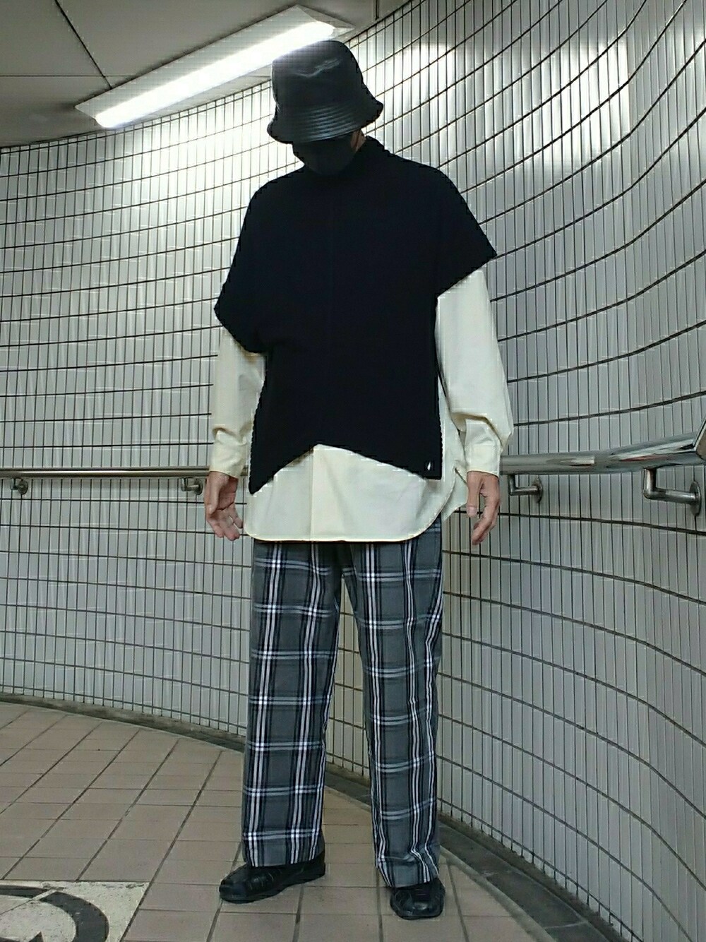 ブラック系のポンチョ、グレー系のパンツ、ブラック系のサンダルを着用したメンズの春コーディネートの1枚目の写真