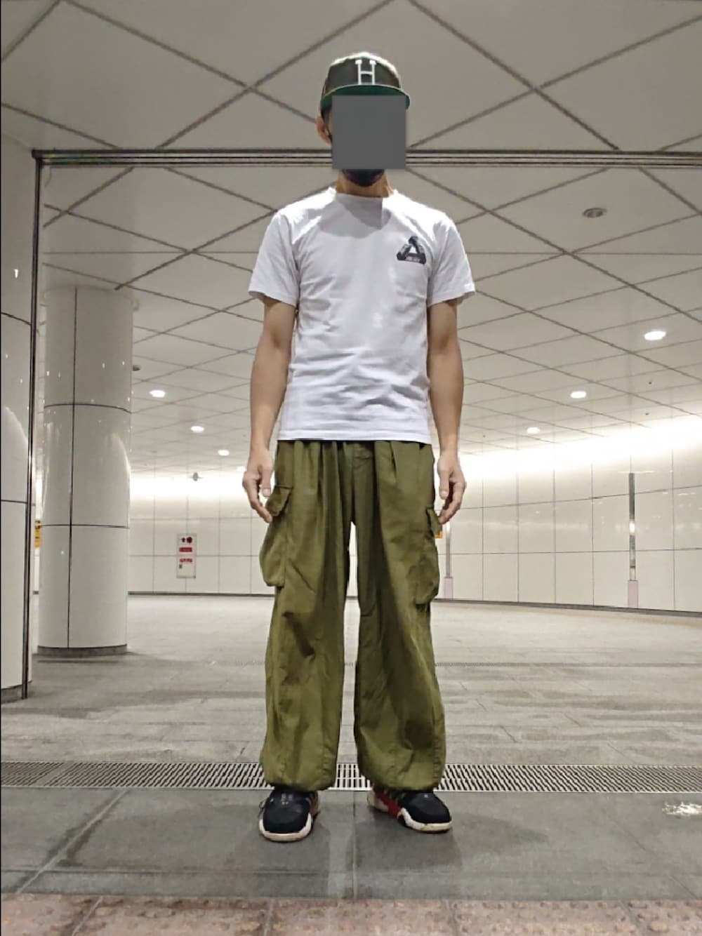 ホワイト系のTシャツ/カットソー、グリーン系のカーゴパンツ、ブラック系のスニーカーを着用したメンズの秋コーディネートの1枚目の写真