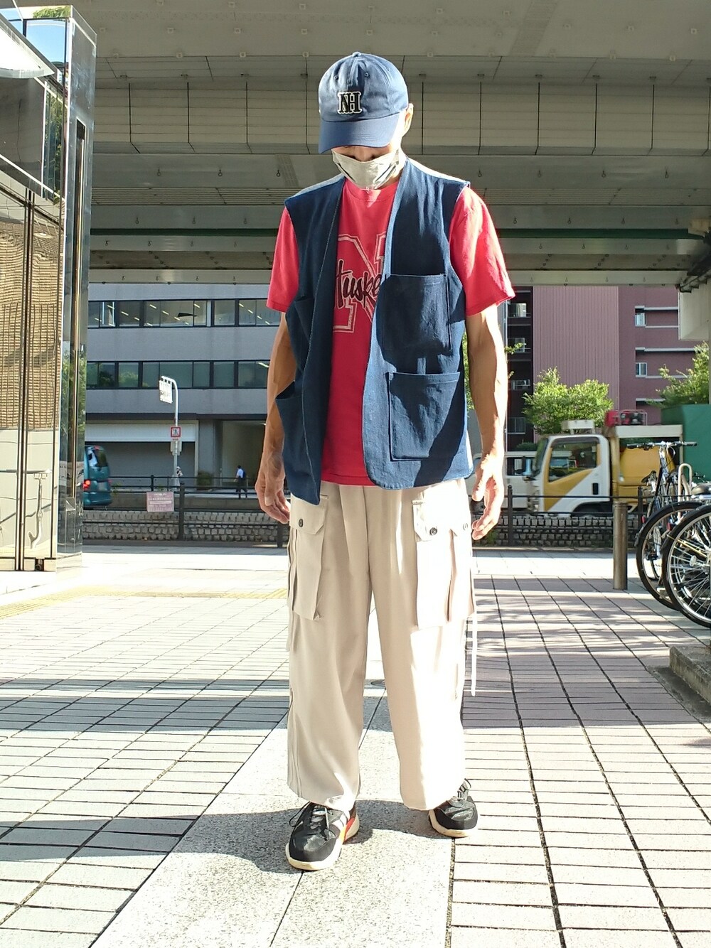 ブルー系のベスト、グレー系のカーゴパンツ、ブラック系のスニーカーを着用したメンズの夏コーディネートの1枚目の写真