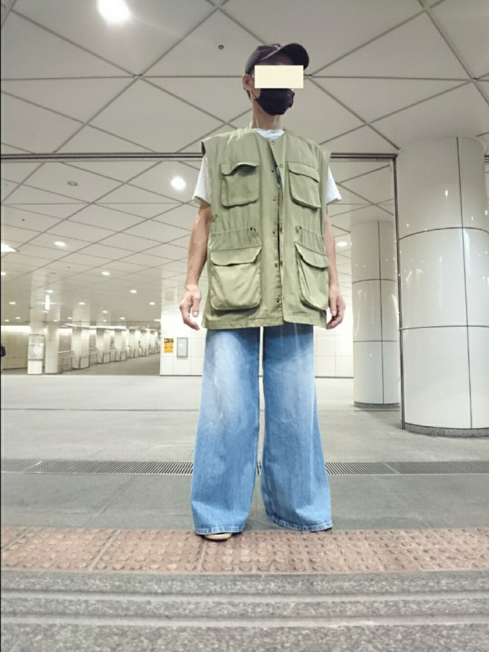 ホワイト系のTシャツ/カットソー、グリーン系のベスト、ブルー系のデニムパンツを着用したメンズの秋コーディネートの1枚目の写真