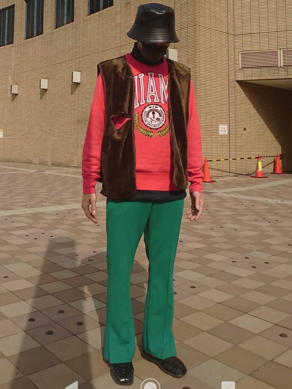 レッド系のスウェット、ブラウン系のベスト、グリーン系のスラックスを着用したメンズの春コーディネートの1枚目の写真