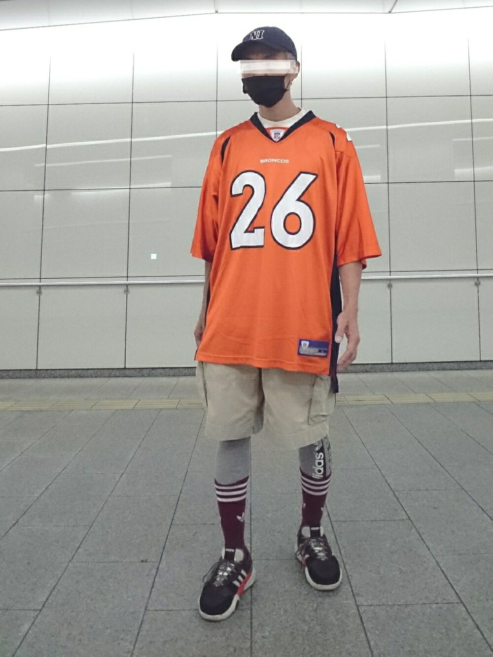 オレンジ系のTシャツ/カットソー、ホワイト系のTシャツ/カットソー、ブラック系のスニーカーを着用したメンズの秋コーディネートの1枚目の写真