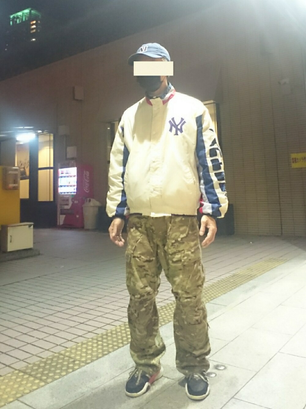 ホワイト系のブルゾン、グリーン系のカーゴパンツ、ブラック系のスニーカーを着用したメンズの冬コーディネートの1枚目の写真