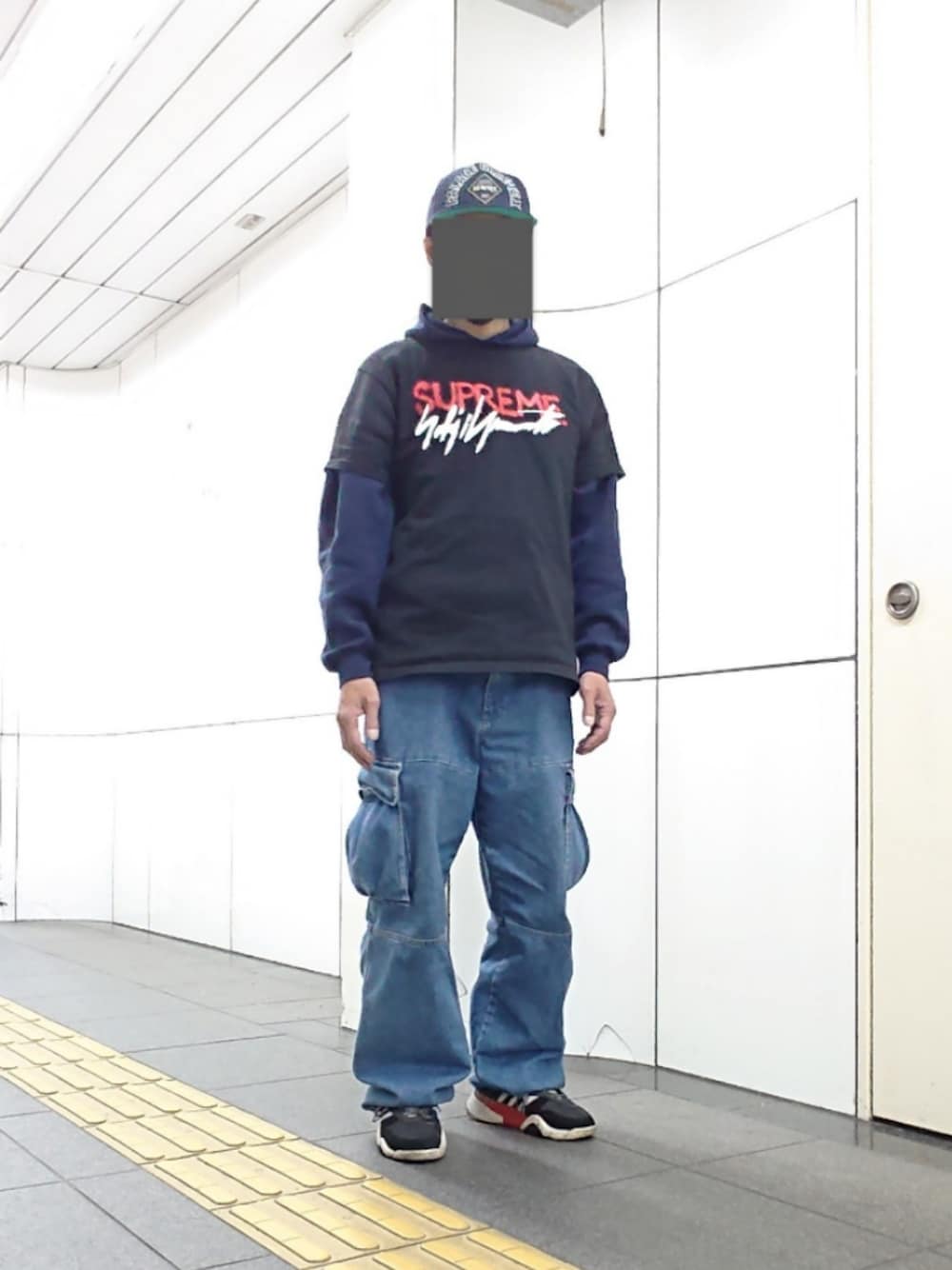 ブラック系のTシャツ/カットソー、ブルー系のカーゴパンツ、ブラック系のスニーカーを着用したメンズの春コーディネートの1枚目の写真