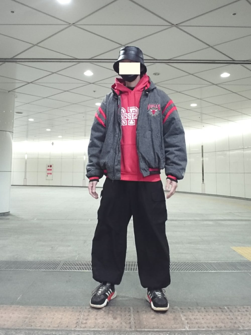 グレー系のブルゾン、ブラック系のカーゴパンツ、ブラック系のスニーカーを着用したメンズの冬コーディネートの1枚目の写真