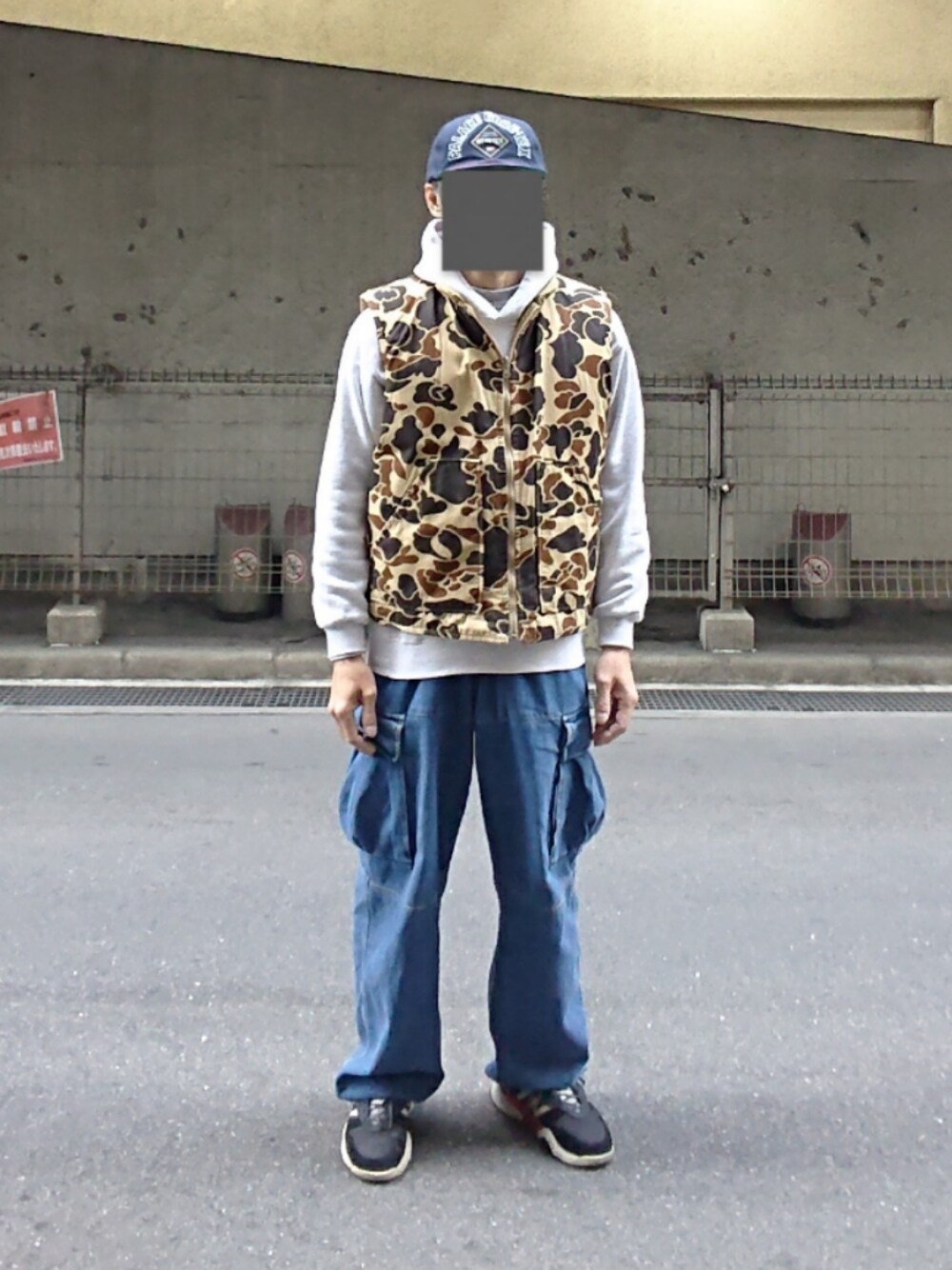 ブルー系のカーゴパンツ、ブラック系のスニーカー、その他のキャップを着用したメンズの春コーディネートの1枚目の写真