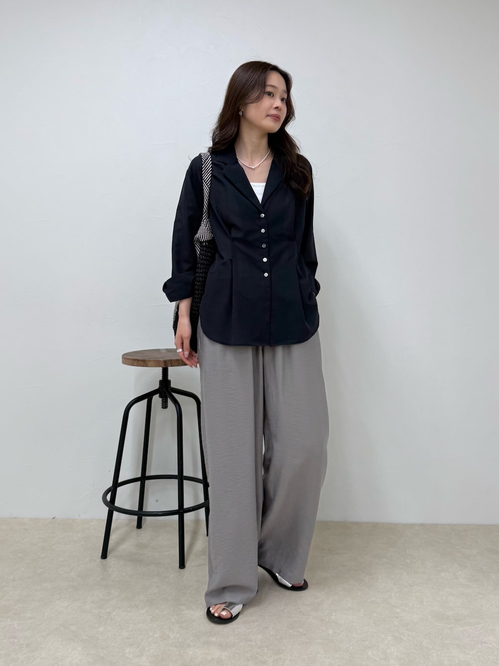 ブルー系のシャツ/ブラウス、グレー系のその他パンツ、ブラック系のトートバッグを着用したレディースの春コーディネートの1枚目の写真