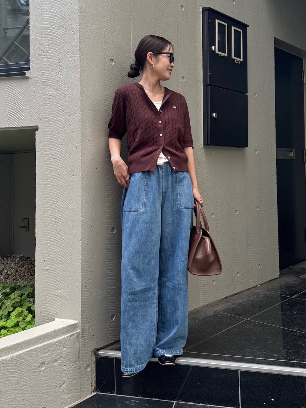 ブルー系のデニムパンツ、ブラウン系のショルダーバッグ、ブラウン系のカーディガン/ボレロを着用したレディースの夏コーディネートの1枚目の写真