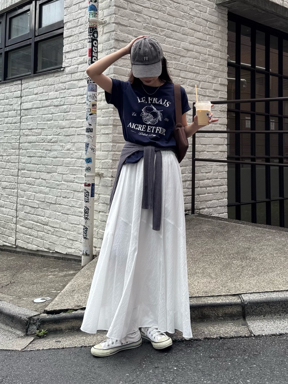 ブルー系のTシャツ/カットソー、ホワイト系のスカート、グレー系のキャップを着用したレディースの夏コーディネートの1枚目の写真
