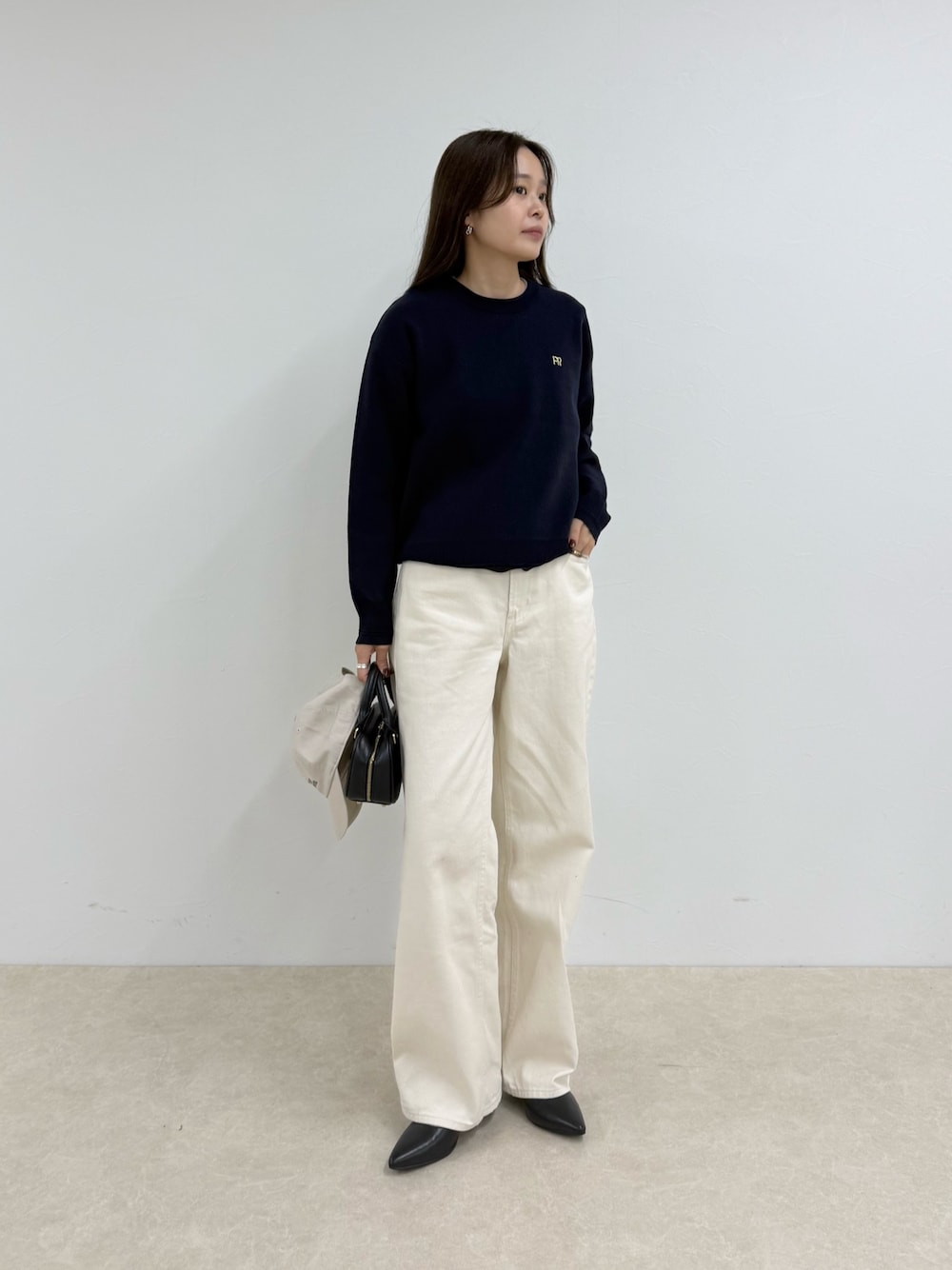 ブルー系のニット/セーター、ホワイト系のデニムパンツ、ホワイト系のキャップを着用したレディースの夏コーディネートの1枚目の写真