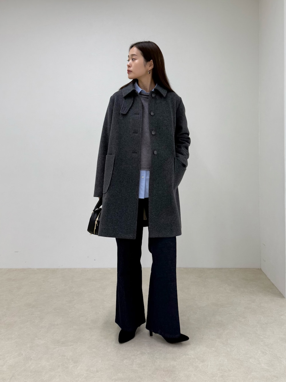 グレー系のダッフルコート、ブルー系のデニムパンツ、グレー系のニット/セーターを着用したレディースの秋コーディネートの1枚目の写真