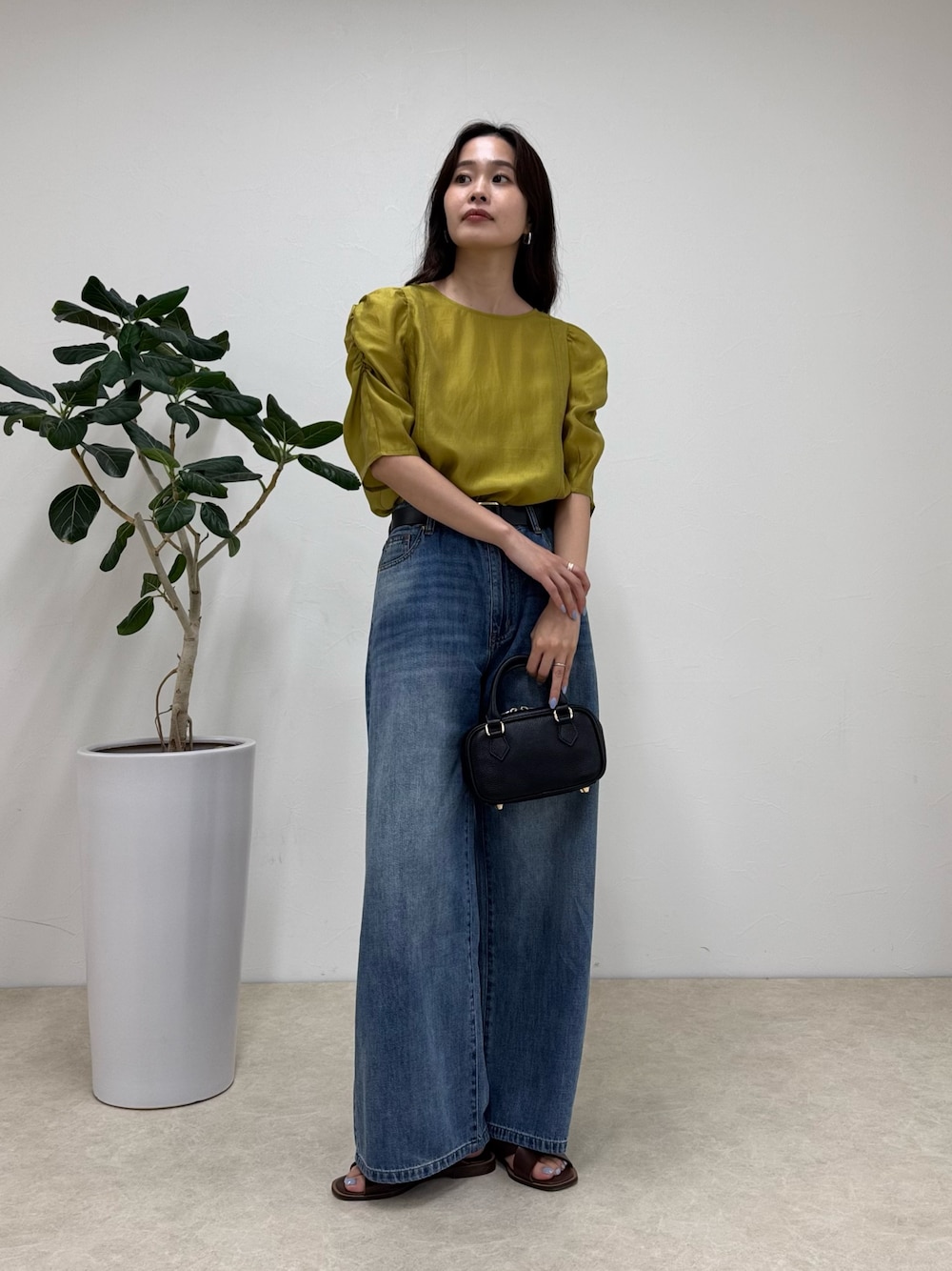 イエロー系のシャツ/ブラウス、ブルー系のデニムパンツ、ブラック系のショルダーバッグを着用したレディースの夏コーディネートの1枚目の写真