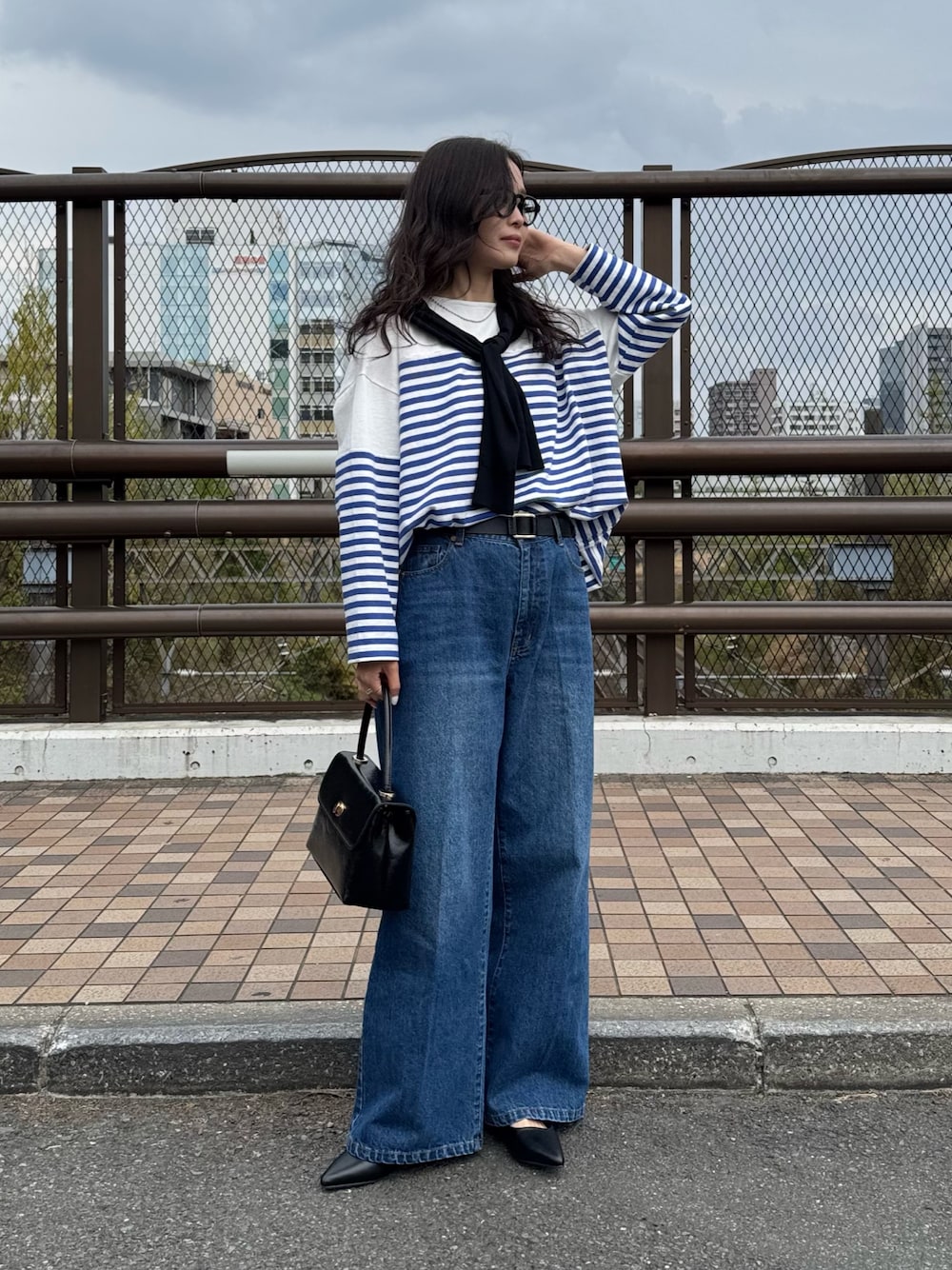 ブルー系のTシャツ/カットソー、ブルー系のデニムパンツ、ブラック系のカーディガン/ボレロを着用したレディースの春コーディネートの1枚目の写真