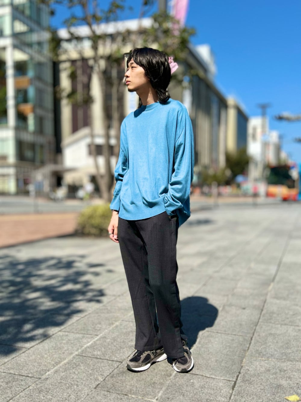 ブルー系のニット/セーター、グレー系のパンツ、ブラック系のスニーカーを着用したメンズの秋コーディネートの1枚目の写真