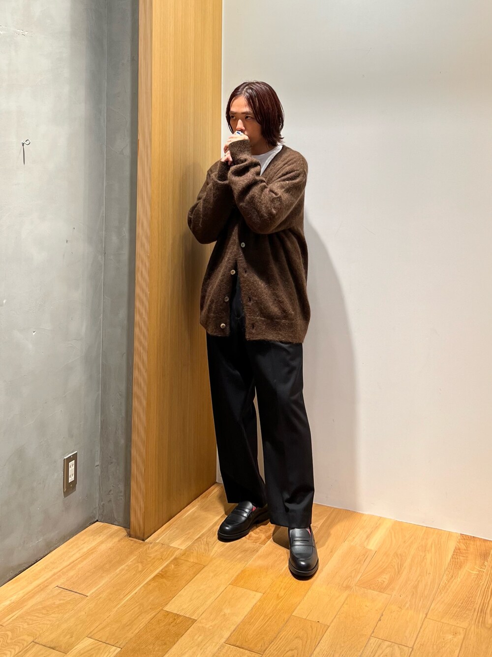 ブラウン系のカーディガン/ボレロ、ベージュ系のTシャツ/カットソー、ブラック系のスラックスを着用したメンズの秋コーディネートの1枚目の写真