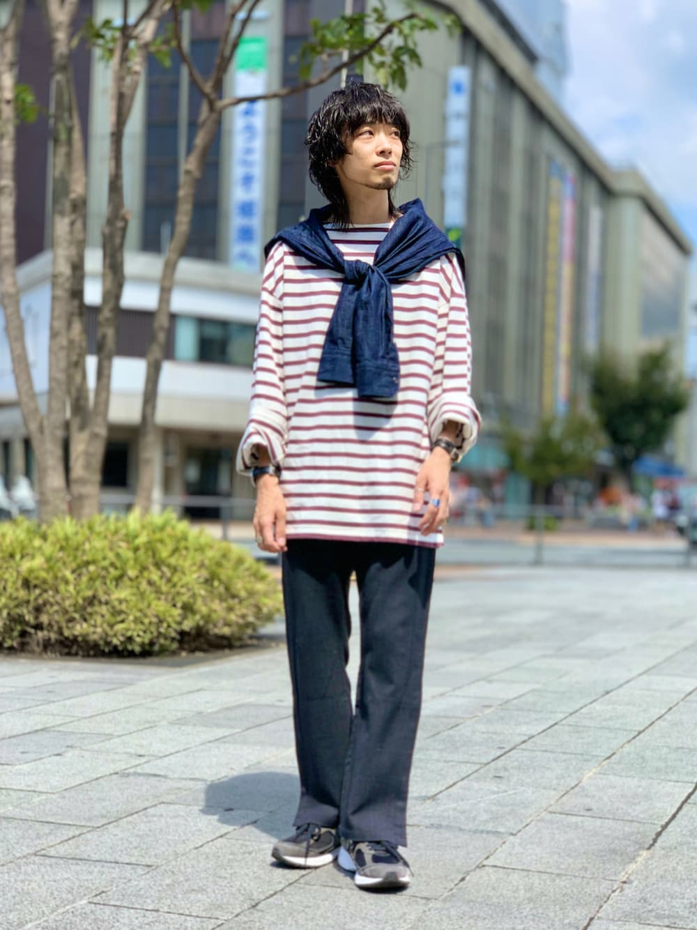 レッド系のTシャツ/カットソー、ブルー系のシャツ/ブラウス、グレー系のパンツを着用したメンズの秋コーディネートの1枚目の写真