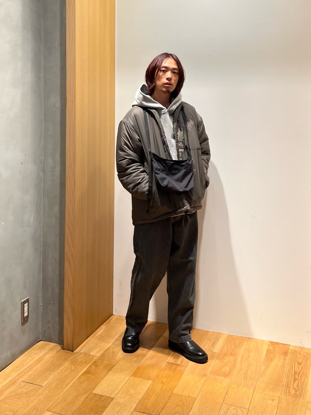 グリーン系のブルゾン、グレー系のパーカー、グレー系のデニムパンツを着用したメンズの秋コーディネートの1枚目の写真