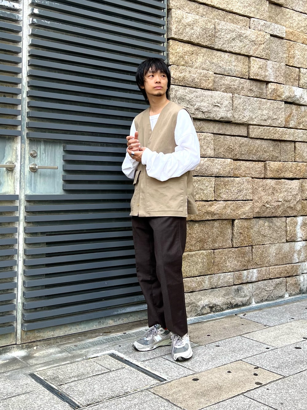 ベージュ系のベスト、ホワイト系のTシャツ/カットソー、ブラウン系のパンツを着用したメンズの夏コーディネートの1枚目の写真