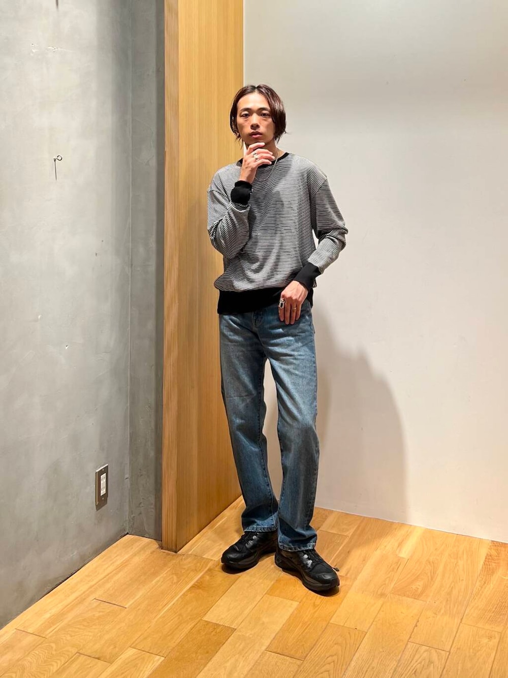 ホワイト系のニット/セーター、ブラック系のスニーカー、ブルー系のデニムパンツを着用したメンズの秋コーディネートの1枚目の写真