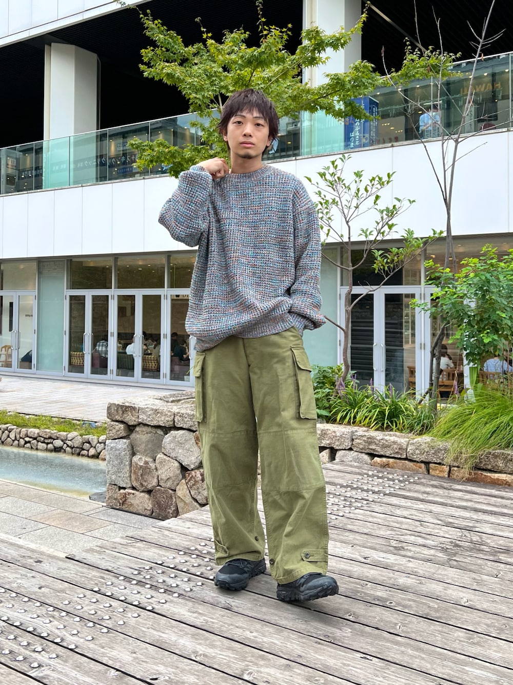ブルー系のニット/セーター、グリーン系のカーゴパンツ、ブラック系のスニーカーを着用したメンズの秋コーディネートの1枚目の写真