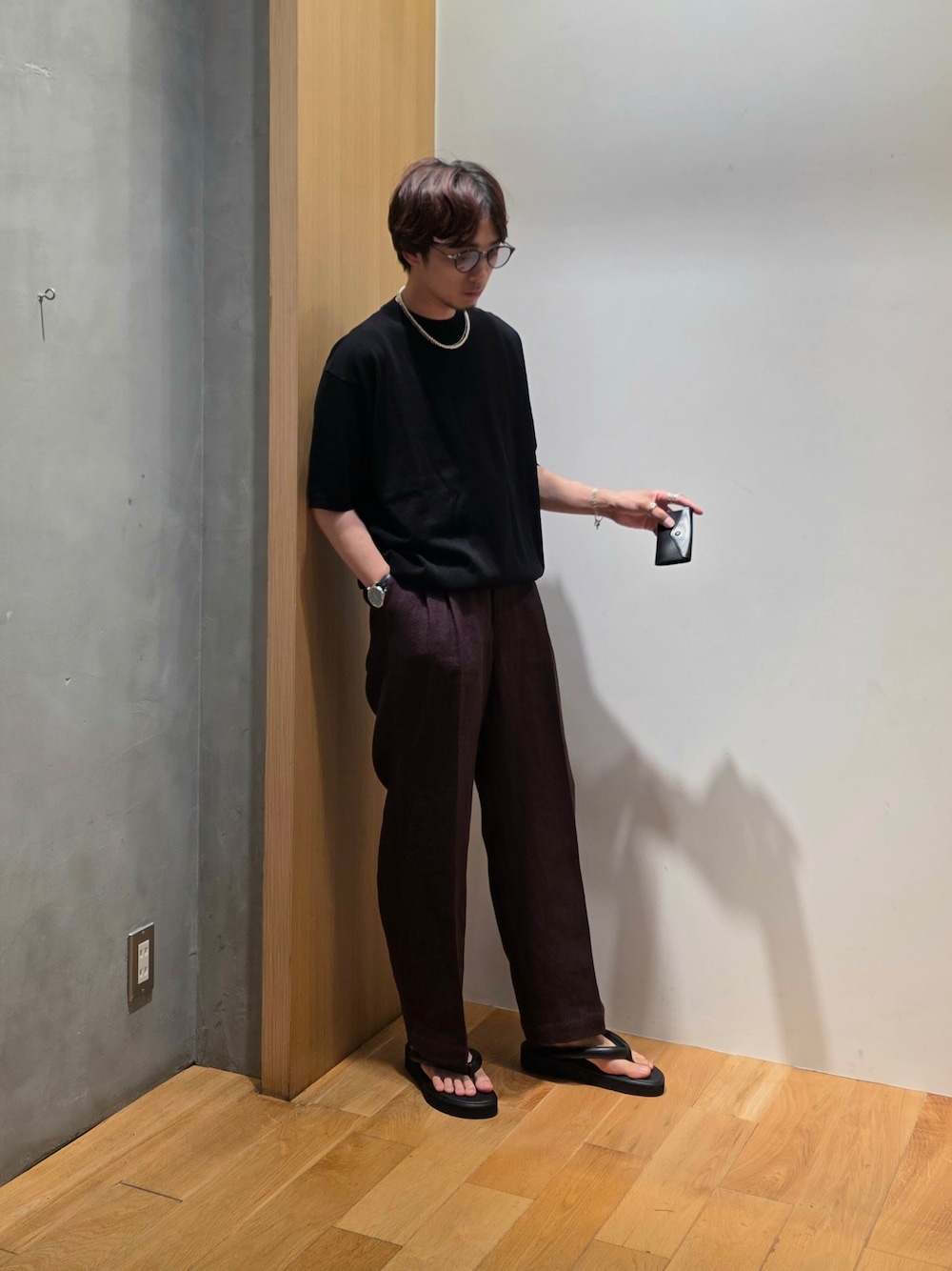 ブラック系のニット/セーター、ブラウン系のその他パンツ、ブラック系の名刺入れを着用したメンズの夏コーディネートの1枚目の写真