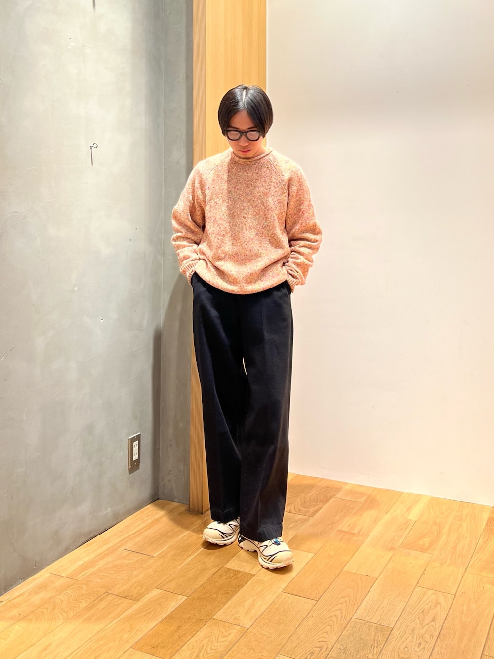 オレンジ系のニット/セーター、ブラック系のデニムパンツ、ベージュ系のスニーカーを着用したメンズの冬コーディネートの1枚目の写真