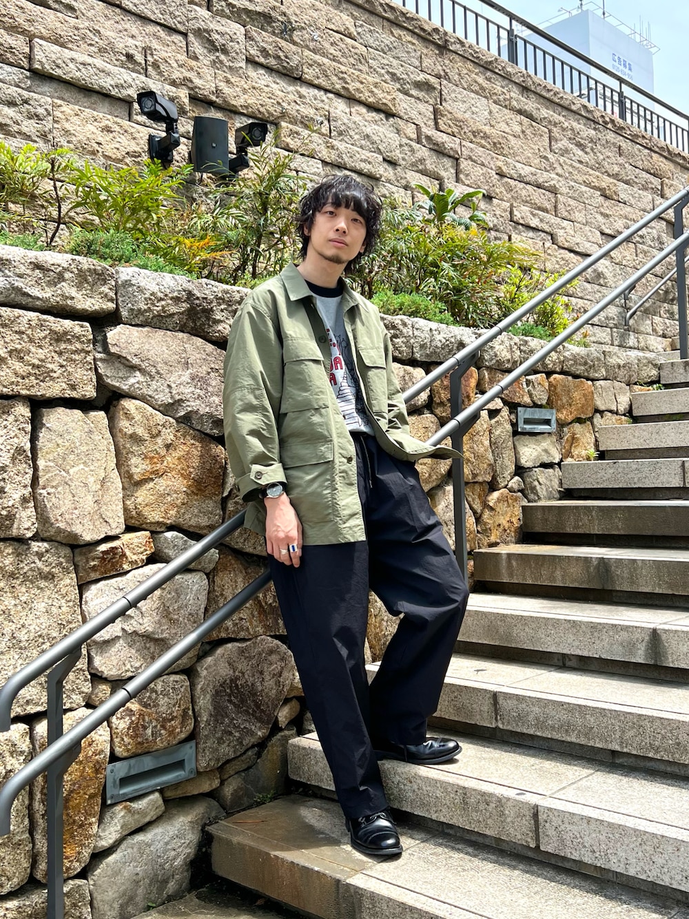 グレー系のTシャツ/カットソー、グリーン系のミリタリージャケット、ブラック系のその他パンツを着用したメンズの春コーディネートの1枚目の写真