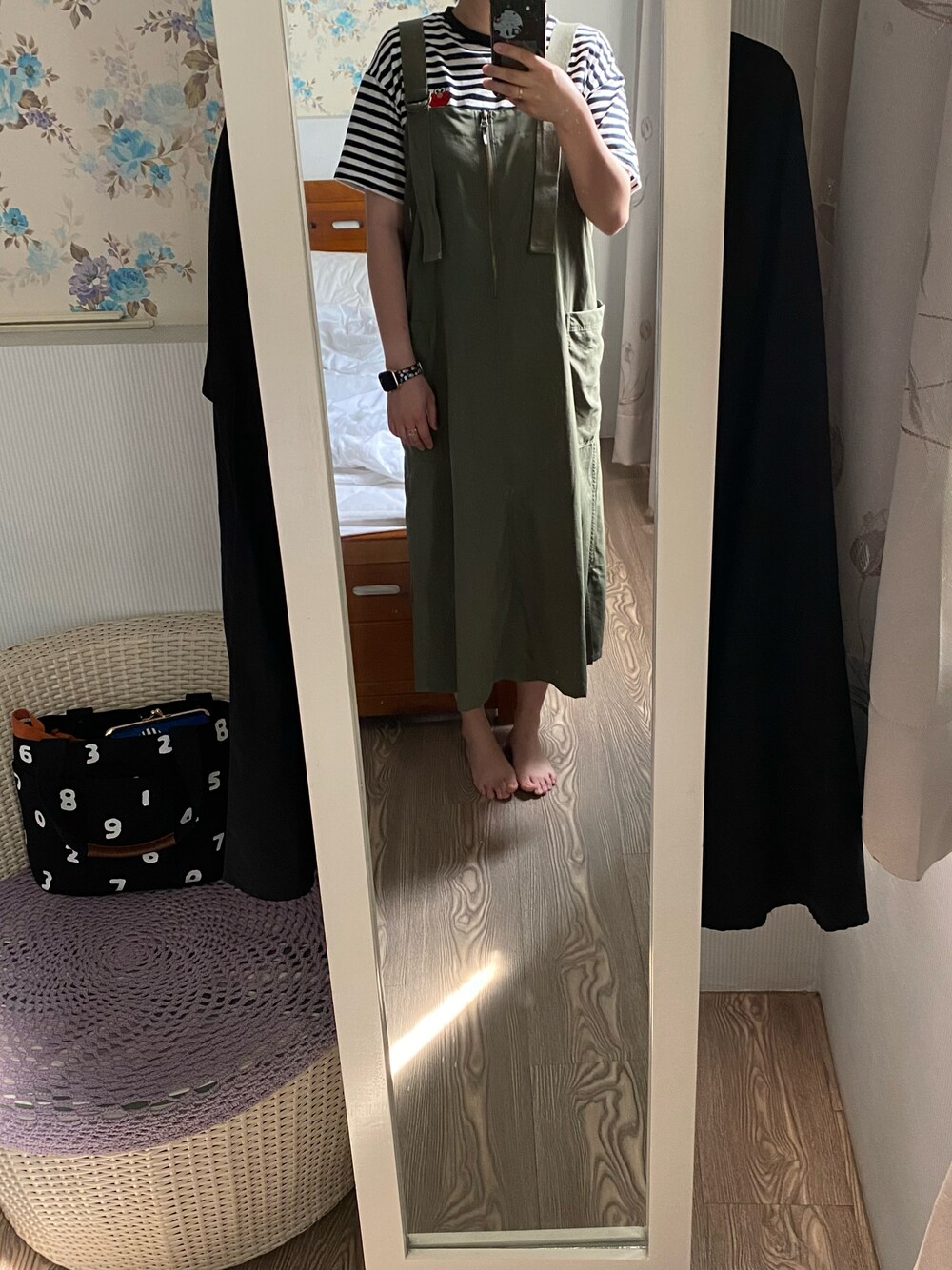 グリーン系のジャンパースカートを着用したレディースの夏コーディネートの1枚目の写真