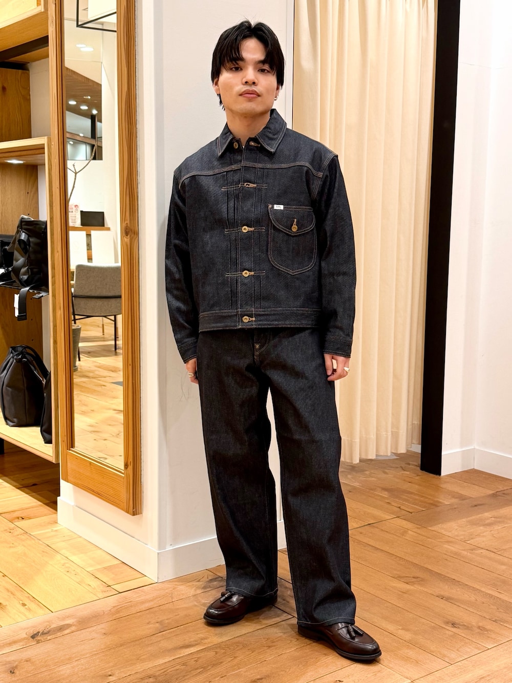 ブルー系のデニムジャケット、ブルー系のデニムパンツ、ブラウン系のドレスシューズを着用したメンズの冬コーディネートの1枚目の写真