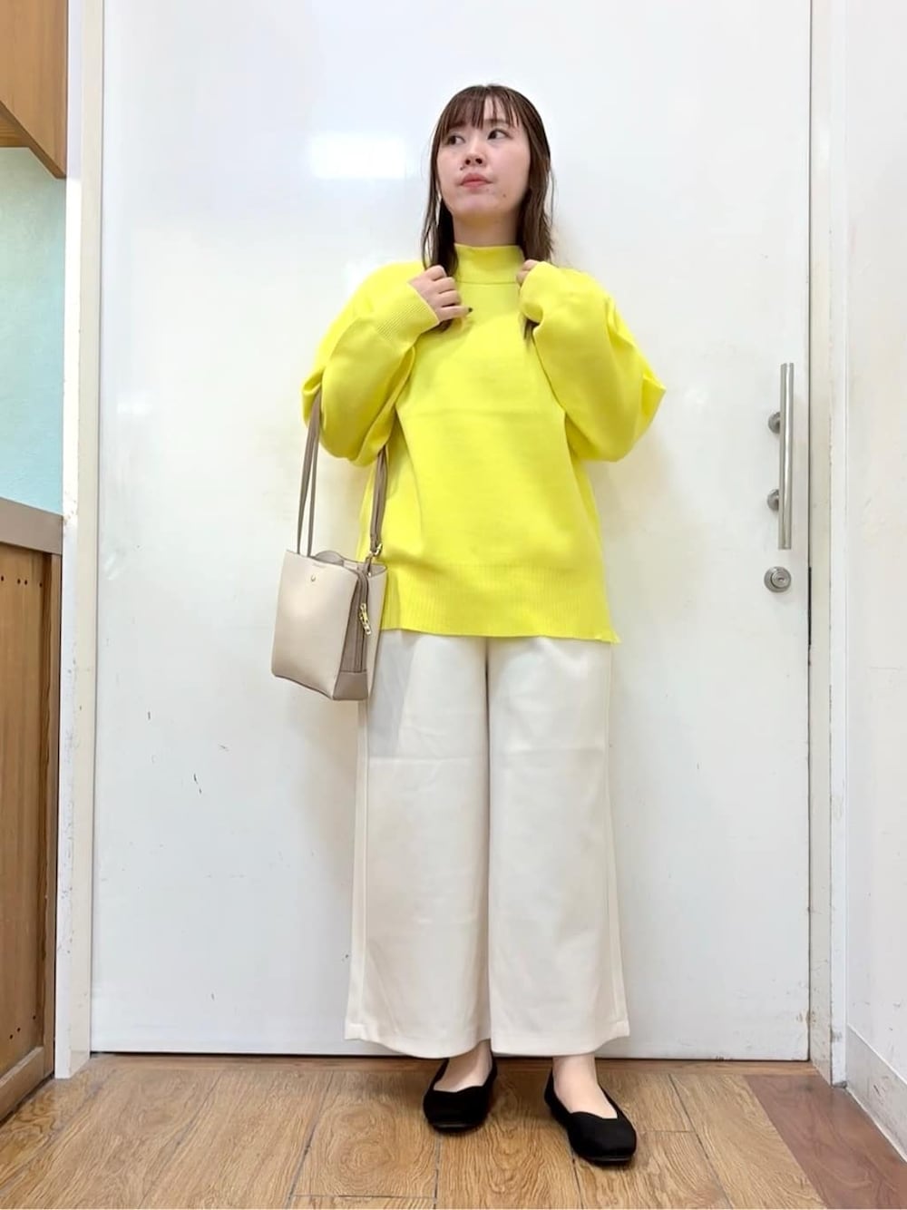イエロー系のニット/セーター、ホワイト系のその他パンツ、ブラック系のパンプスを着用したレディースの冬コーディネートの1枚目の写真