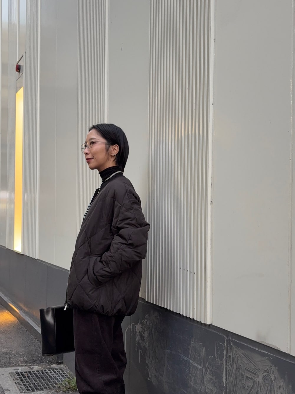 ブラック系のダウンジャケット/コート、ブラック系のTシャツ/カットソー、グレー系のその他パンツを着用したレディースの冬コーディネートの1枚目の写真