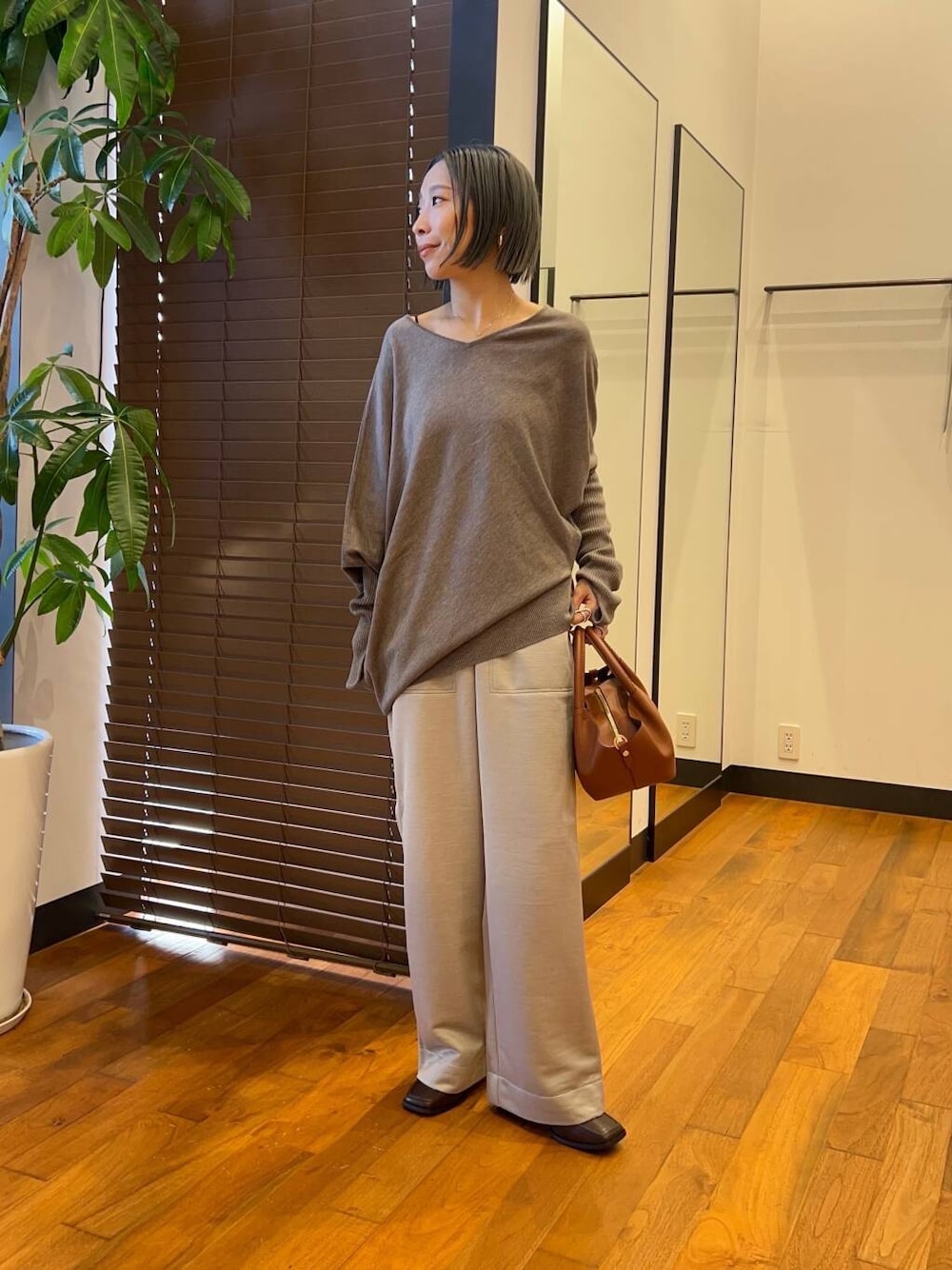 グレー系のその他パンツ、ブラウン系のブーツ、グレー系のニット/セーターを着用したレディースの秋コーディネートの1枚目の写真