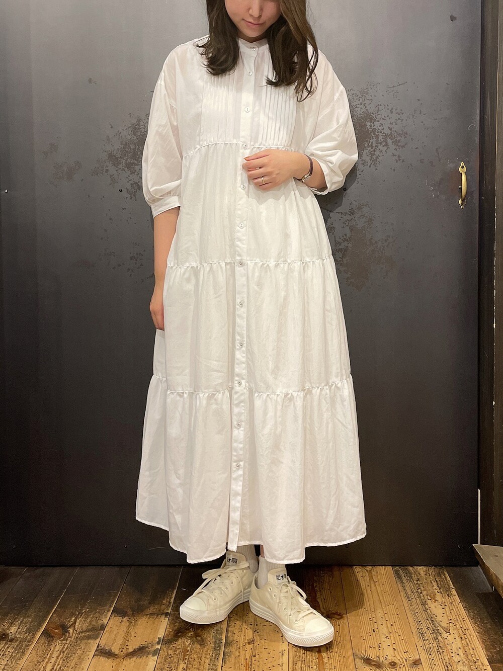 ホワイト系のスニーカー、ホワイト系のワンピース、ホワイト系のスカートを着用したレディースの秋コーディネートの1枚目の写真