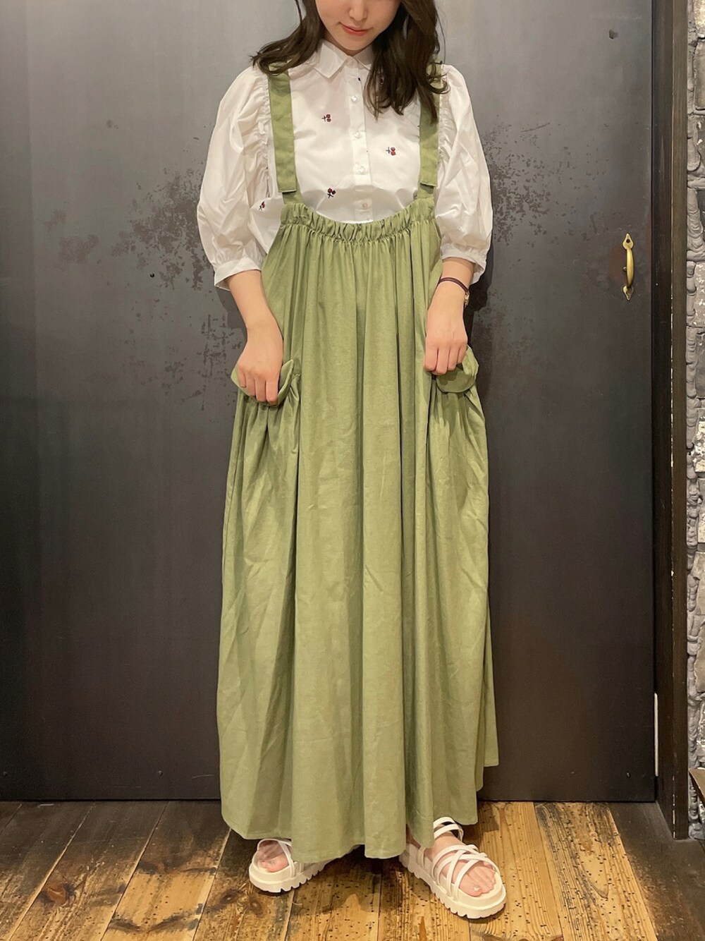 ホワイト系のシャツ/ブラウス、グリーン系のジャンパースカートを着用したレディースの夏コーディネートの1枚目の写真