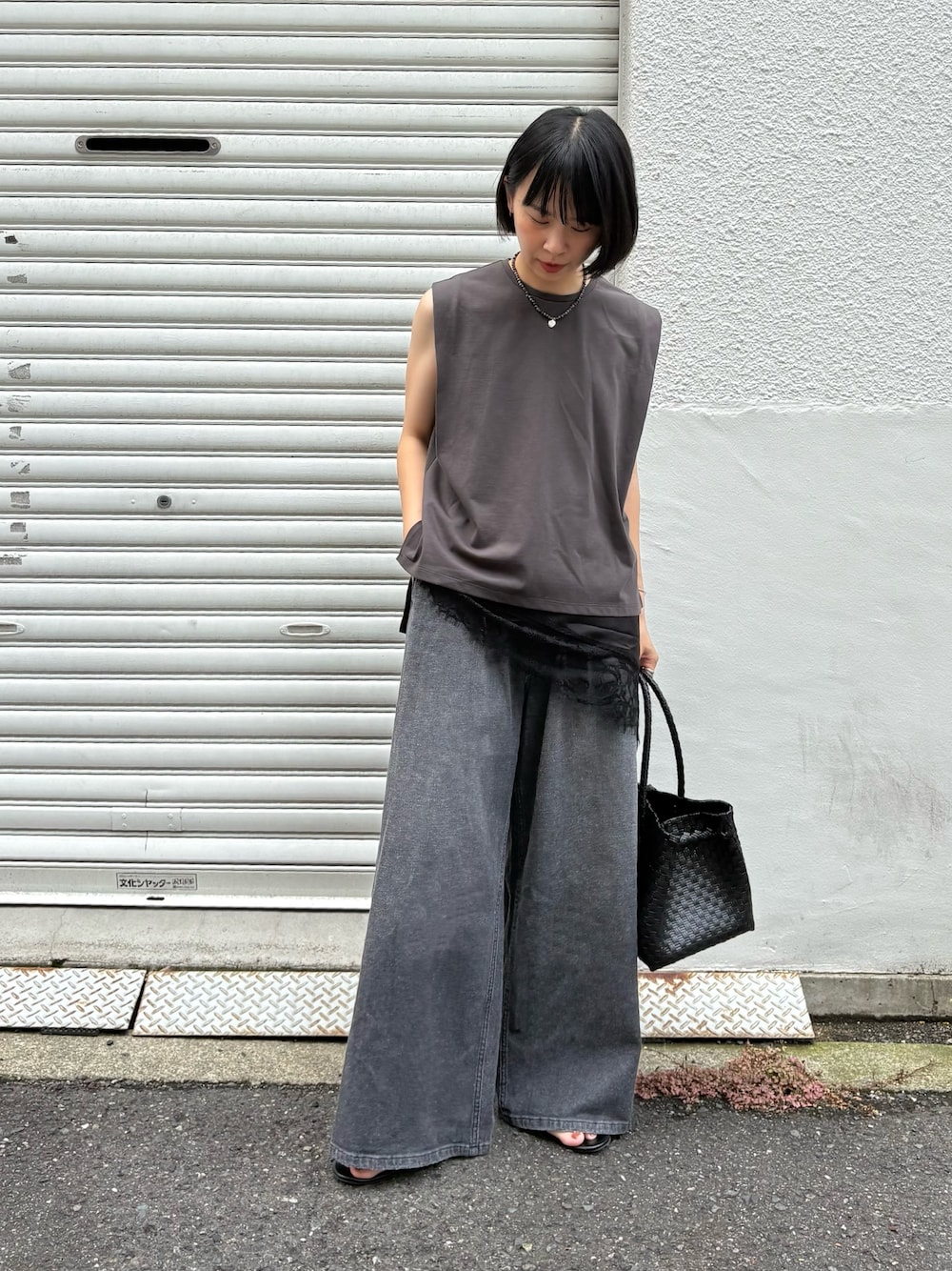 ブラック系のキャミソール、ブラック系のデニムパンツ、ブラック系のトートバッグを着用したレディースの夏コーディネートの1枚目の写真