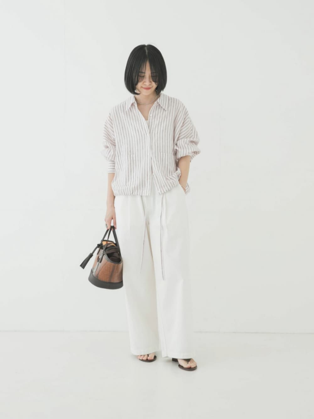 レッド系のシャツ/ブラウス、ブラウン系のかごバッグ、ホワイト系のその他パンツを着用したレディースの春コーディネートの1枚目の写真