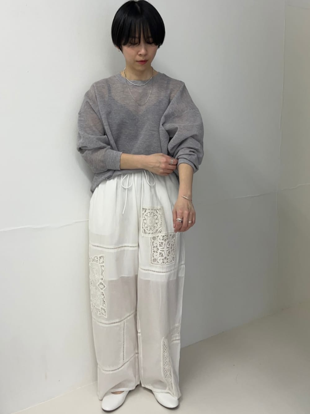 グレー系のニット/セーター、ホワイト系のバレエシューズを着用したレディースの春コーディネートの1枚目の写真