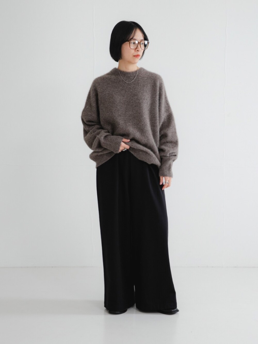 ブラウン系のニット/セーター、ブラック系のその他パンツ、ブラック系のローファーを着用したレディースの秋コーディネートの1枚目の写真