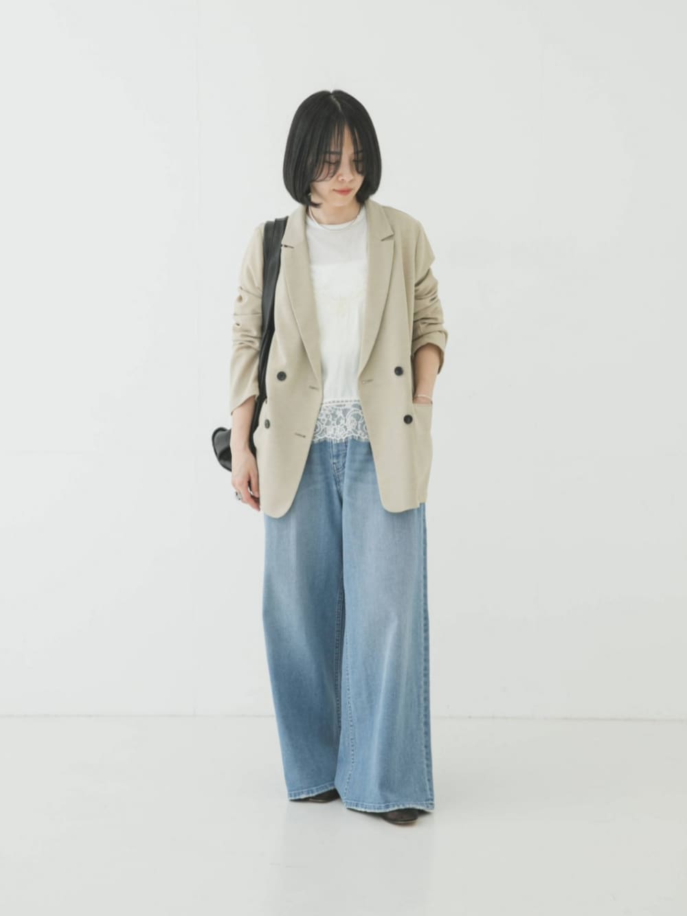 ベージュ系のその他アウター、ブルー系のデニムパンツ、ホワイト系のキャミソールを着用したレディースの春コーディネートの1枚目の写真