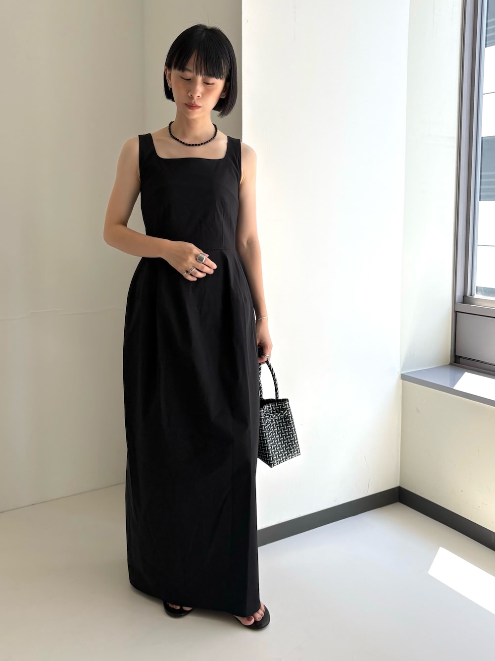 その他のトートバッグ、ブラック系のサンダル、ブラック系のワンピースを着用したレディースの夏コーディネートの1枚目の写真