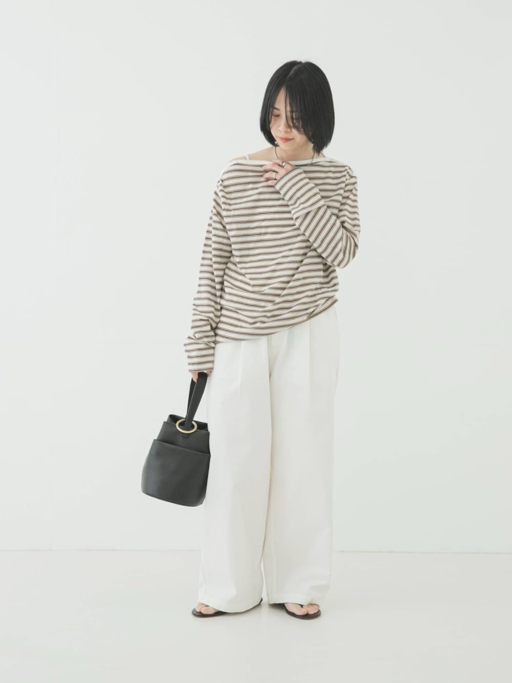 ホワイト系のTシャツ/カットソー、ブラック系のハンドバッグ、ホワイト系のその他パンツを着用したレディースの春コーディネートの1枚目の写真