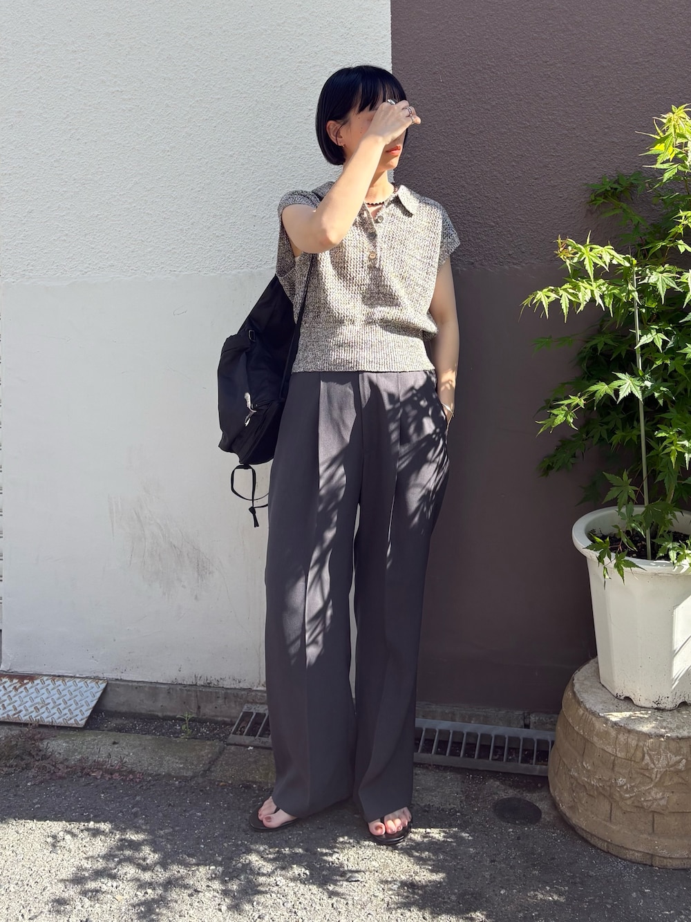 ブラック系のサンダル、グレー系のその他パンツ、ブラック系のバックパック/リュックを着用したレディースの夏コーディネートの1枚目の写真